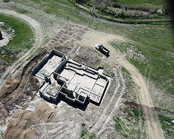 Aerial picture of basement with concrete poured and backfill done