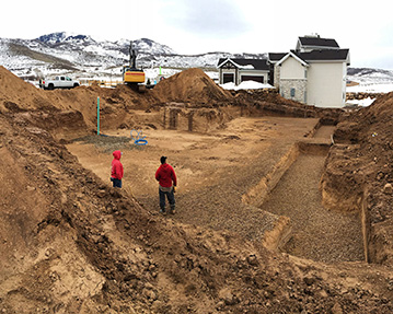 Two men standing in freshly dug basement